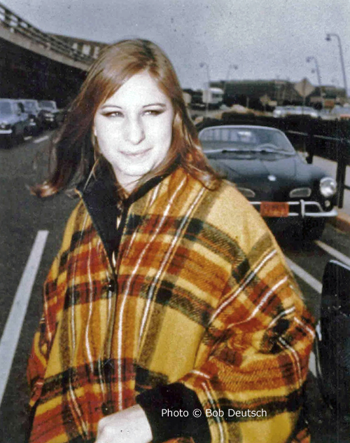 Streisand in plaid poncho at airport